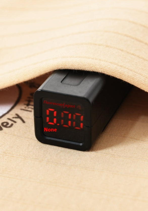 Fluorescent agent detection device with digital display on a wooden surface