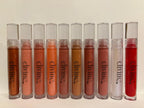 Row of 'divine' lip glosses in various colors on a light background